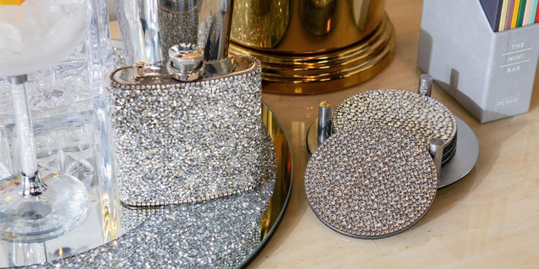 Rhinestone flask and matching coasters on a mirrored bar tray