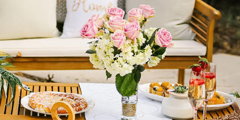 Floral brunch table with a clear vase trimmed in gold rhinestones and champagne flutes