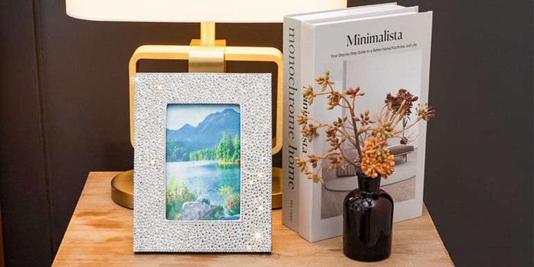 Rhinestone picture frame styled on a bedside table with lamp and books