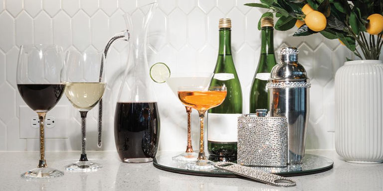 Glassware and silver bar accessories styled on a mirrored tray