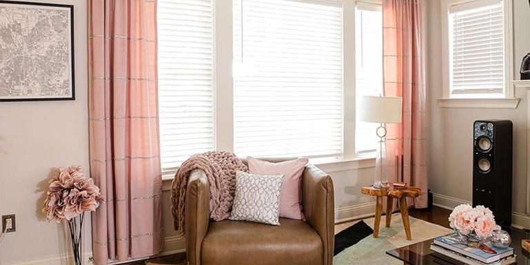 Blush living room with pink curtains, leather chair, and a lattice accent pillow