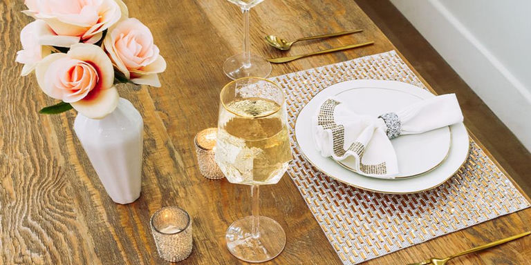 Elegant place setting with metallic placemat, white napkin, and sparkling accents