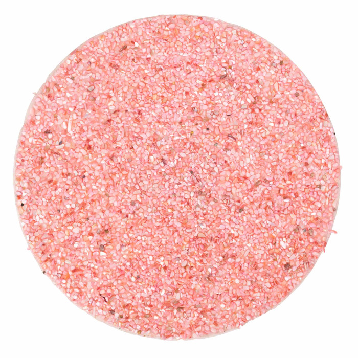 Round placemat made of pink resin with embedded small seashells and a textured surface.