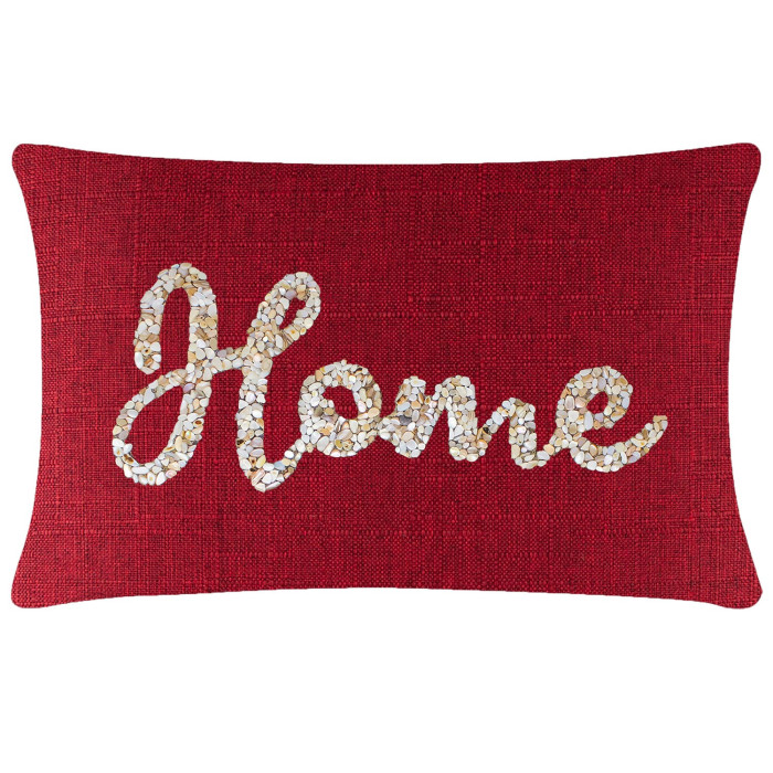 Red rectangular pillow with textured fabric featuring seashells forming the word "Home" in white and beige tones.
