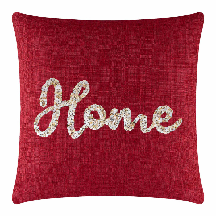 Red square pillow with textured fabric featuring seashells arranged in "Home" script in cream and beige tones.