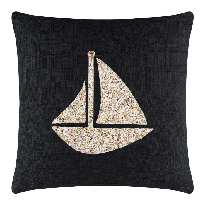 Black pillow featuring a textured fabric with a seashell sailboat design in shades of beige and cream.