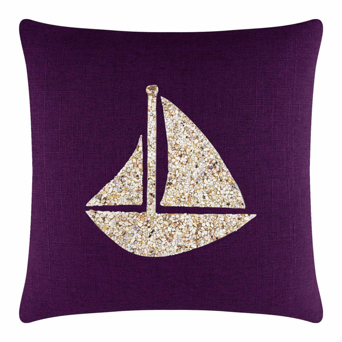 Purple pillow featuring a seashell sailboat design in cream and beige textured fabric on a smooth background.
