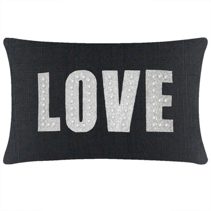 Black rectangular pillow featuring the word "LOVE" in rhinestones and faux pearls on a textured fabric surface.