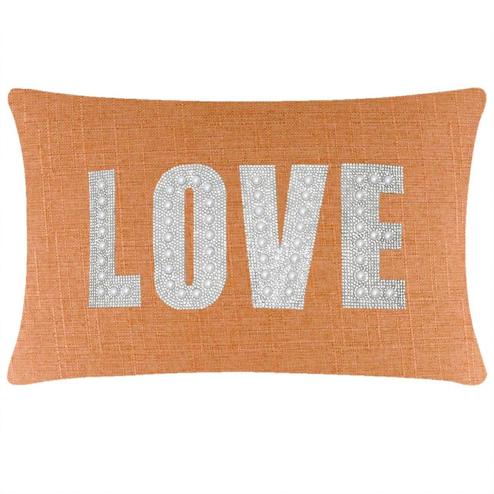 Rectangular orange pillow with a woven texture featuring the word "LOVE" in rhinestones and faux pearls.