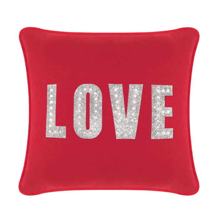 Red velvet pillow featuring the word "LOVE" in rhinestones and faux pearls with a smooth texture and piped edges.
