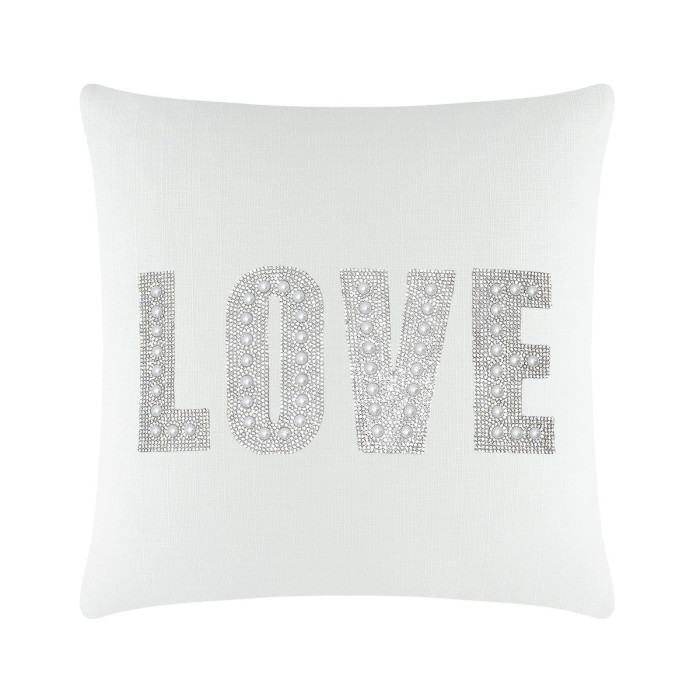 White square pillow featuring the word "LOVE" in rhinestones and faux pearls on a textured surface.