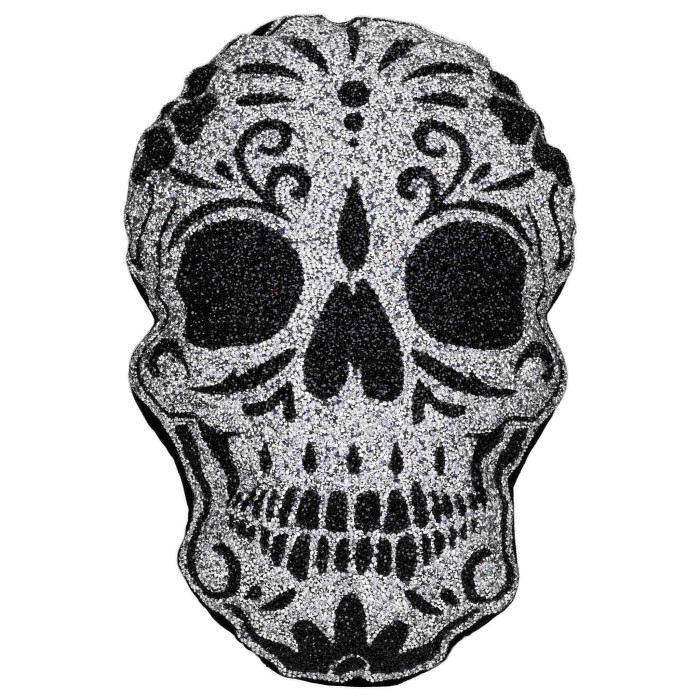 A glittery silver sugar skull pillow with black floral designs and plush texture featuring rhinestone embellishments.