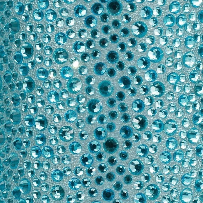 Aqua rhinestones of various sizes set on a textured light background reflecting light with a sparkling effect.