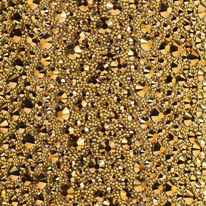 A textured surface covered in various sizes of gold and black rhinestones featuring a sparkling reflective finish.