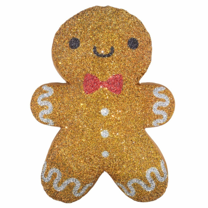Gingerbread man-shaped pillow in golden-brown with rhinestones red bow and white icing details on a textured surface.