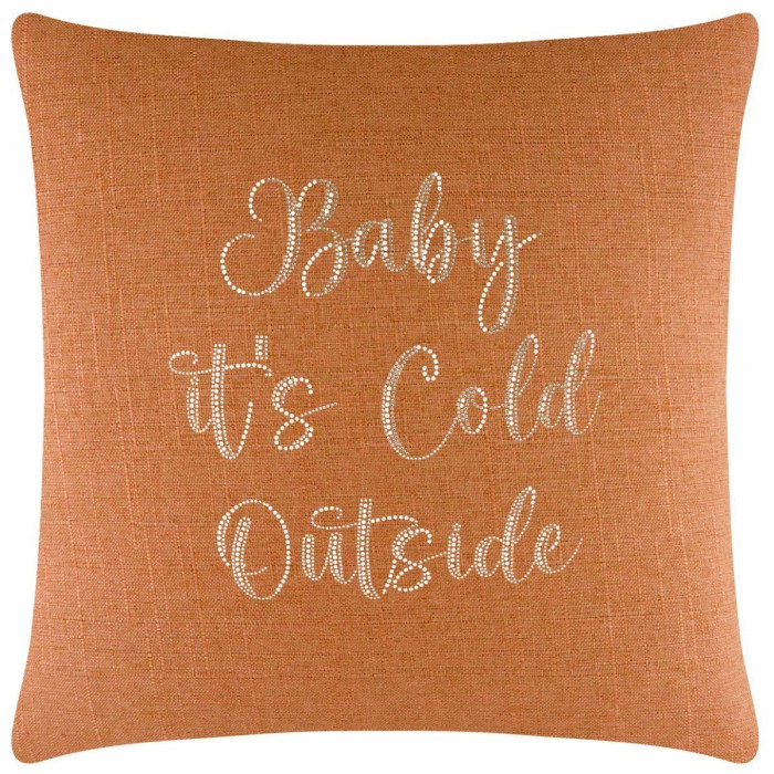 Orange textured pillow with glass rhinestones spelling "Baby it's Cold Outside" in a cursive font.