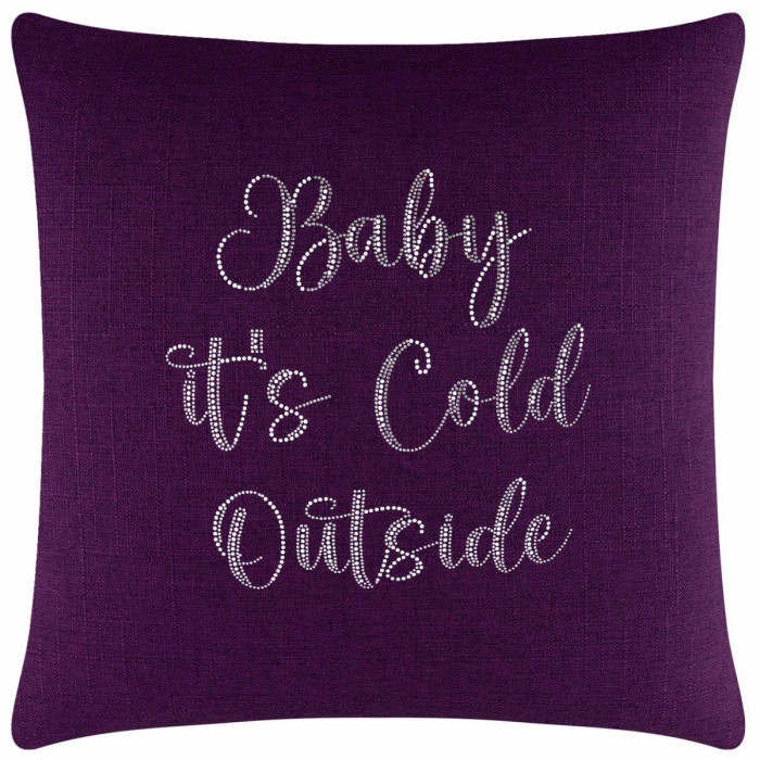Purple textured pillow featuring glass rhinestones spelling "Baby it's Cold Outside" in a cursive font.
