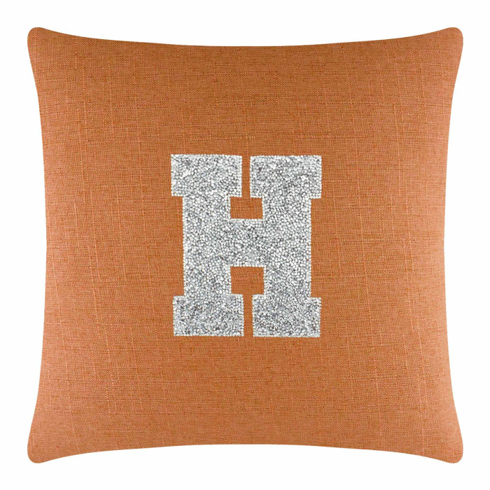 Orange linen pillow featuring a large silver rhinestone monogram letter H in the center.