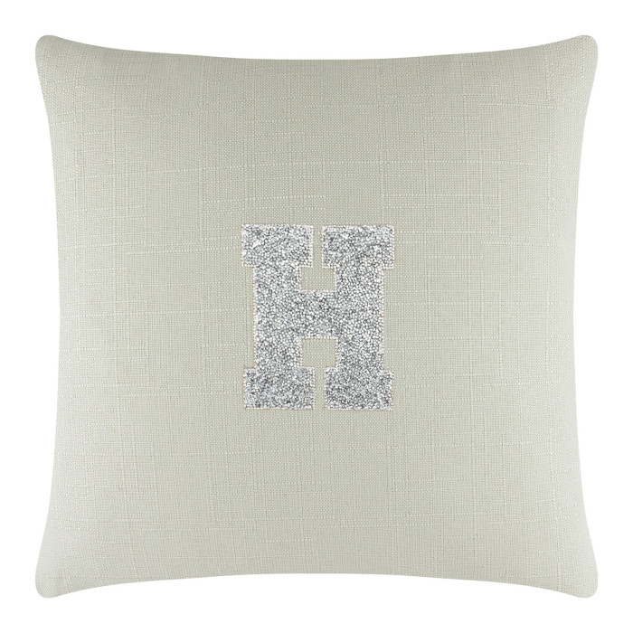 Square light green linen pillow featuring a glittering silver rhinestone monogram letter "H" in the center.