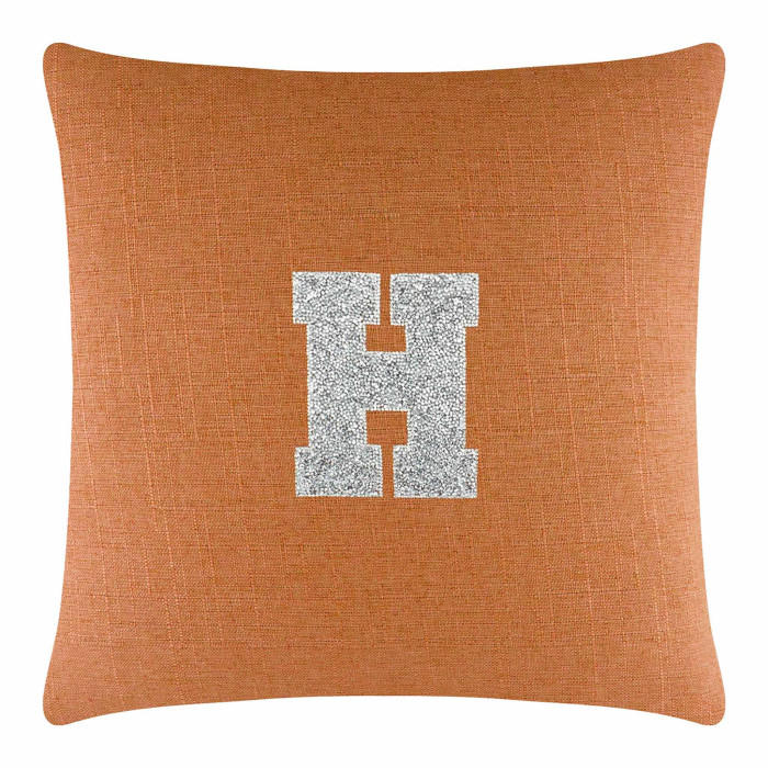 Orange linen pillow featuring a silver rhinestone monogram "H" in the center.
