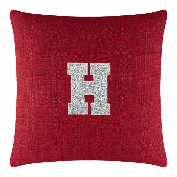 Red square pillow with a textured fabric featuring a silver rhinestone monogram letter "H" in the center.