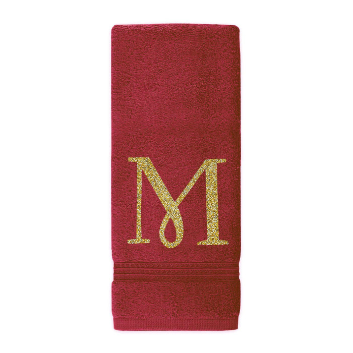 Red plush cotton terry hand towel with a gold glitter rhinestone monogram "M" and decorative trim at the bottom.