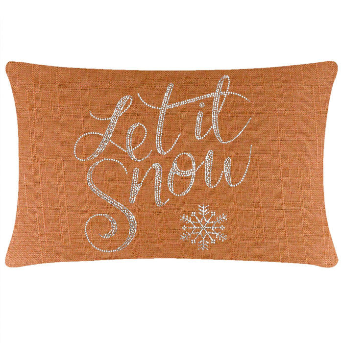 Rectangular orange pillow with a textured fabric featuring silver rhinestone lettering and a snowflake design.