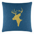 Green velvet pillow featuring a gold glitter reindeer silhouette with antlers on a smooth surface.