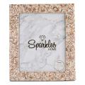 A rectangular picture frame with a shell and bead design in beige cream and soft pink tones surrounding a marble-patterned inner section.