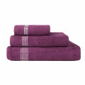 Three stacked towels in black and white featuring rhinestone embellishments on the stripes made of cotton with a plush texture.
