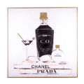 Acrylic wall art featuring a black bottle martini glass and perfume with gold accents on a white background in a metallic frame. Acrylic wall art featuring a black bottle martini glass and perfume with gold accents on a white background in a metallic frame.