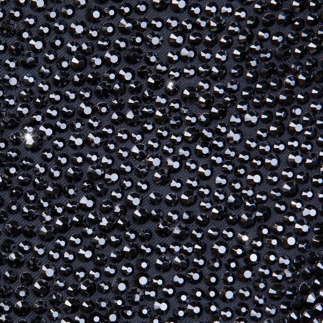 Black blazer covered in shimmering black rhinestones featuring a satin black lapel and two buttons on the front. Black blazer covered in shimmering black rhinestones featuring a satin black lapel and two buttons on the front.