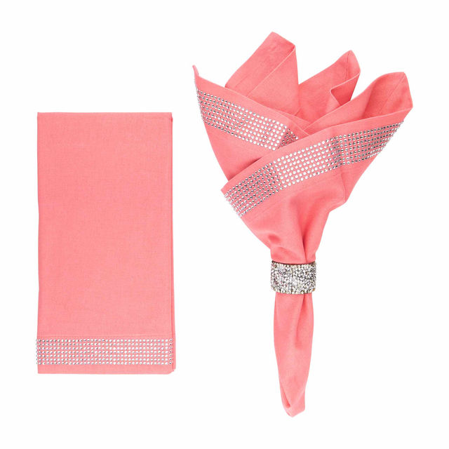 Salmon napkin set featuring a crystal rhinestone band and a smooth texture with one napkin folded and embellished.