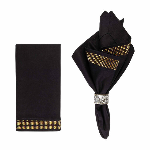 Black napkin with gold rhinestone trim paired with a folded black napkin secured by a crystal rhinestone band.