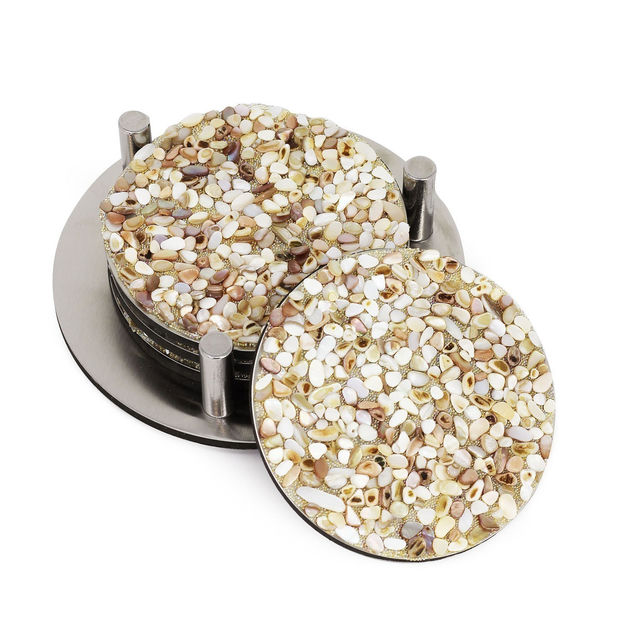 Round coasters made of mixed small shells in beige cream and light brown with a stainless steel base and foam backing.