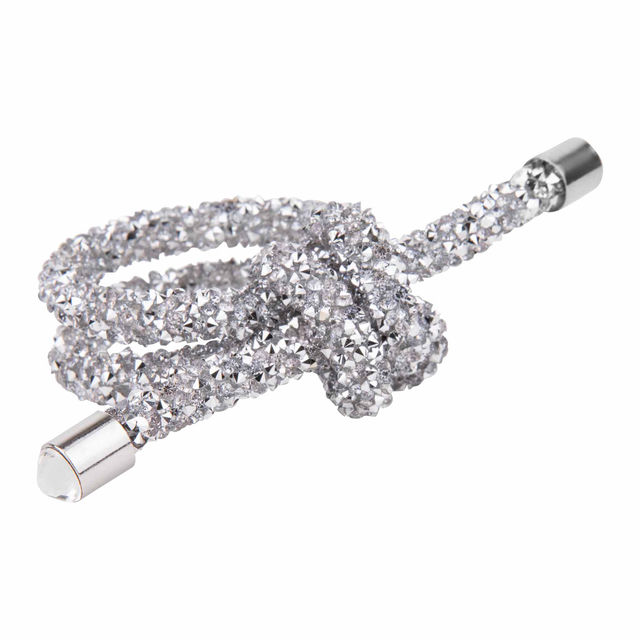 Silver wire napkin ring shaped as a knot embellished with small rhinestones featuring smooth metallic ends.