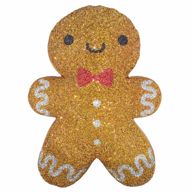 Gingerbread man-shaped pillow in golden-brown with rhinestones red bow and white icing details on a textured surface.