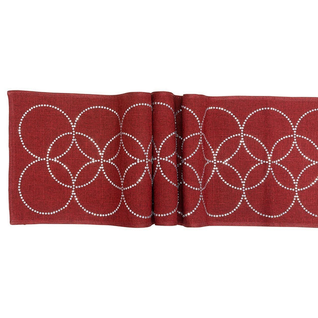 Black table runner with overlapping circles made of glass rhinestones on a textured fabric surface. Black table runner with overlapping circles made of glass rhinestones on a textured fabric surface.