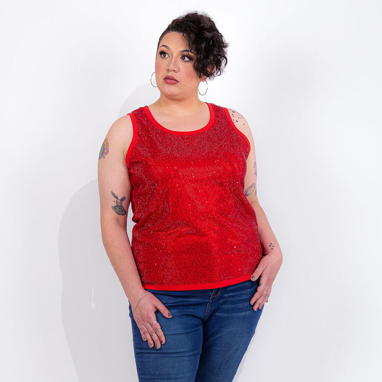 Woman wearing a red rhinestone tank top with a straight fit and blue jeans