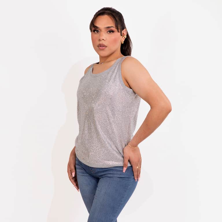 Silver tank top covered in glass rhinestones with a straight fit and a contrasting gray neckline worn with jeans.