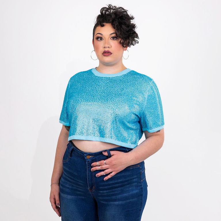 Aqua rhinestone crop top with short sleeves modeled with dark blue jeans