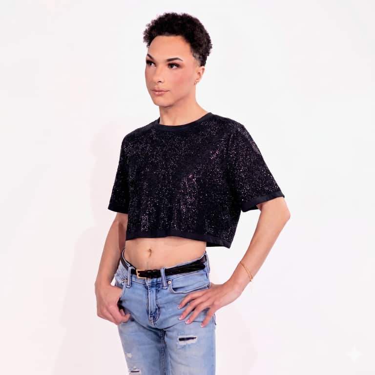 Model wearing a black short-sleeve rhinestone crop top with a shimmering finish
