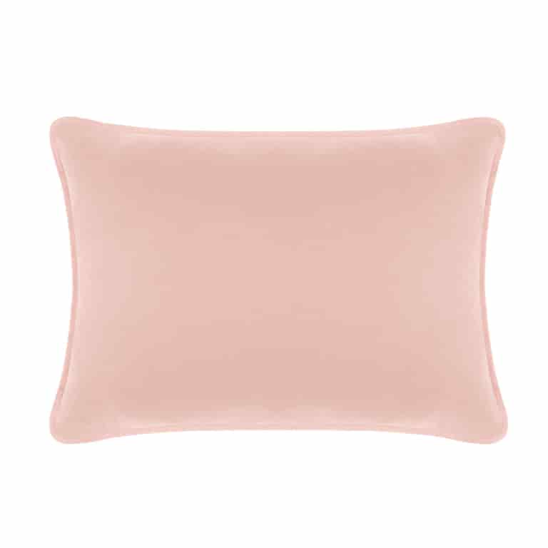 Blush velvet rectangular pillow with a smooth texture and rounded edges.