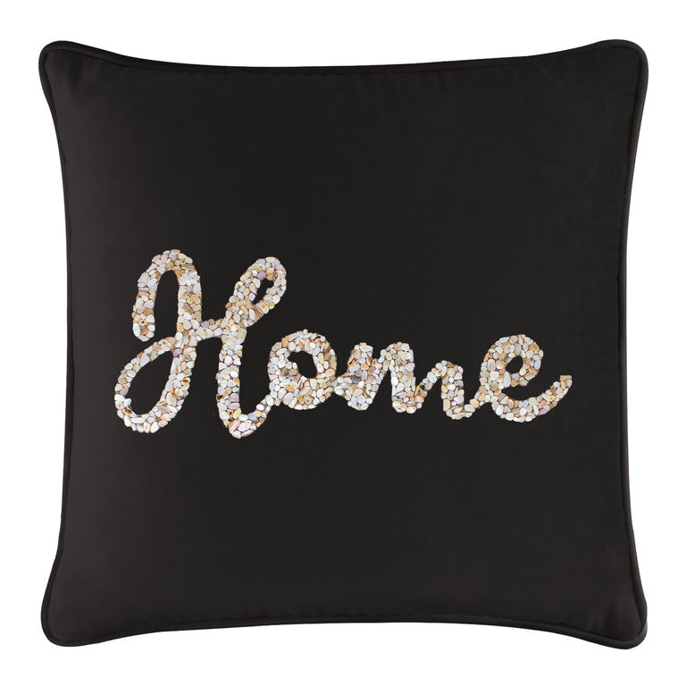 Black velvet pillow featuring a seashell design spelling "Home" in cream and tan hues with a plush texture.