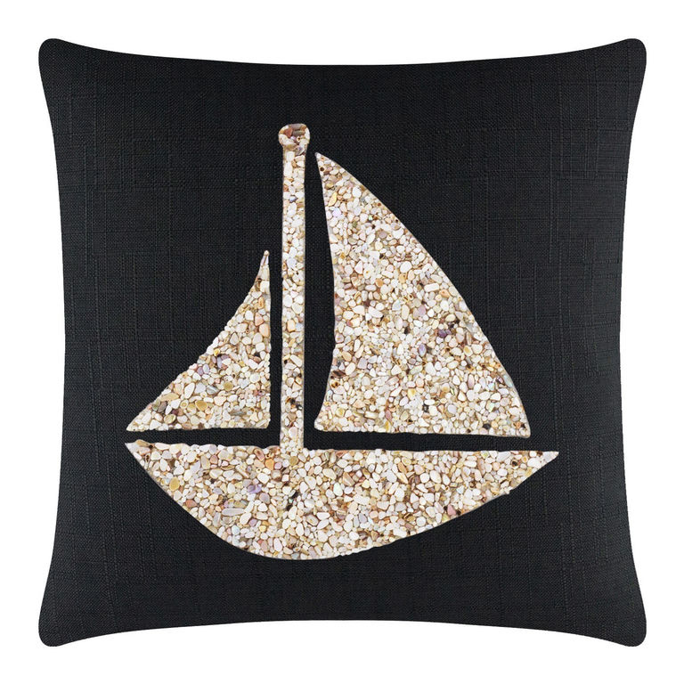Black pillow featuring a seashell sailboat design in beige and cream tones with a textured fabric background.