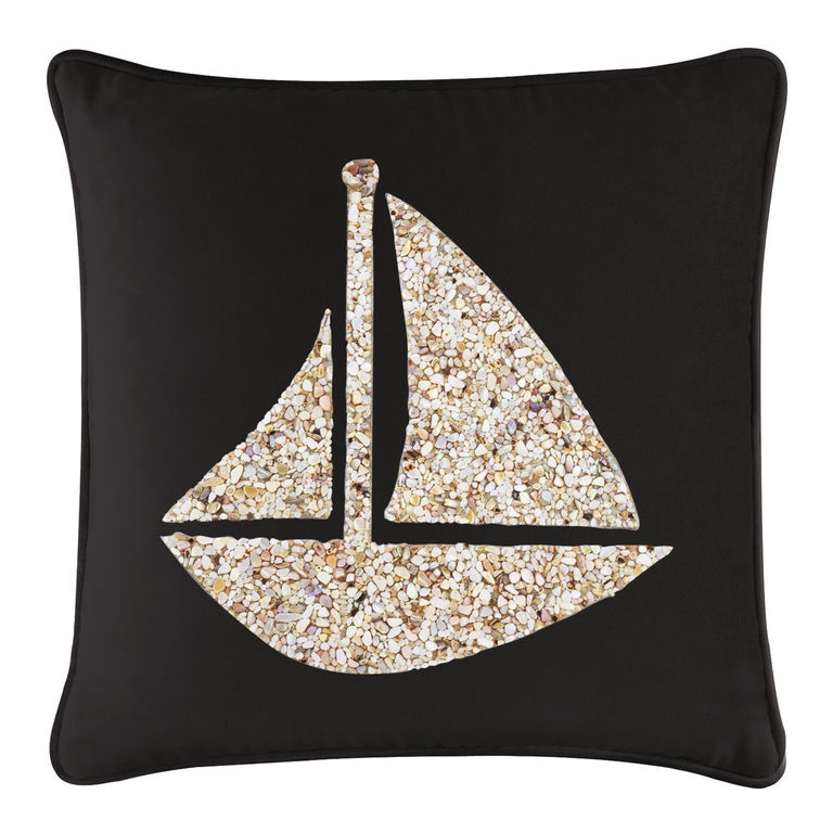 Black velvet pillow featuring a seashell sailboat design in beige and cream tones with a smooth texture and piped edges.