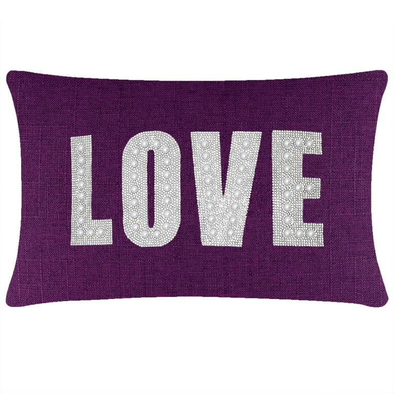 Purple rectangular pillow with "LOVE" in rhinestones and faux pearls on a textured woven surface.