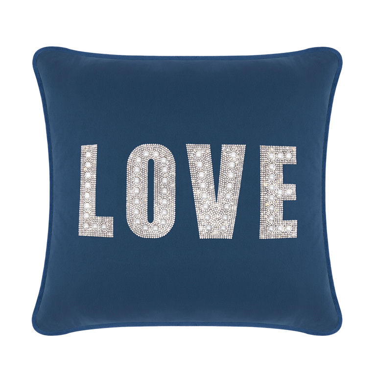 Navy velvet pillow with large "LOVE" text embellished with rhinestones and faux pearls on a smooth surface.