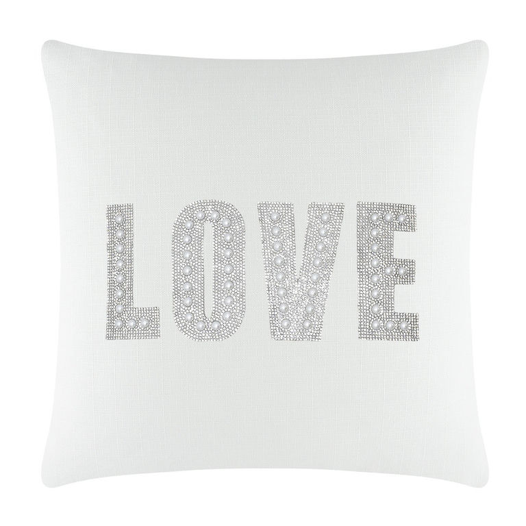 White square pillow featuring the word "LOVE" in rhinestones and faux pearls on a textured surface.