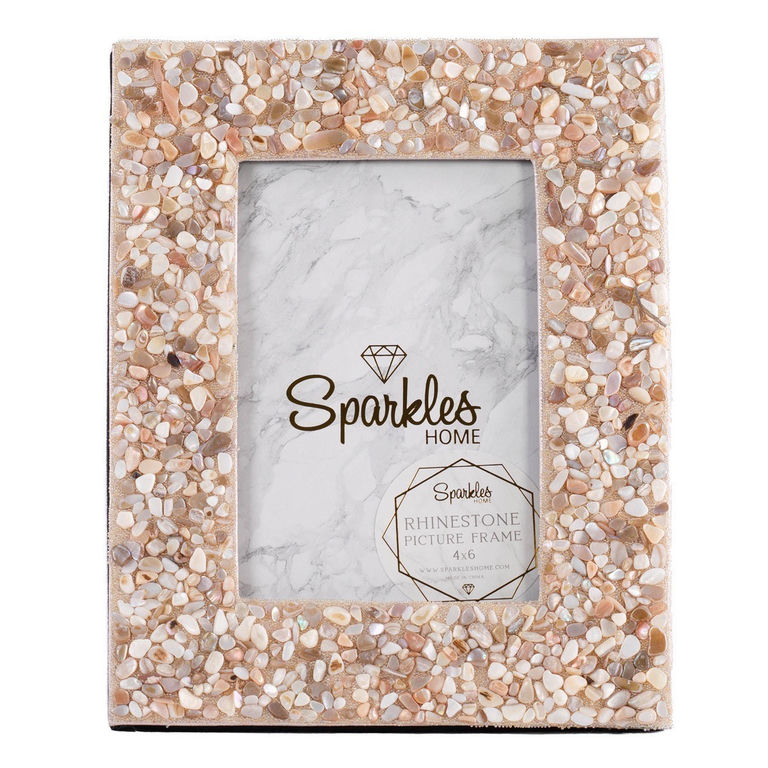 A rectangular picture frame with a seashell and glass bead embellishment in beige and soft pink tones featuring a marble-like interior.